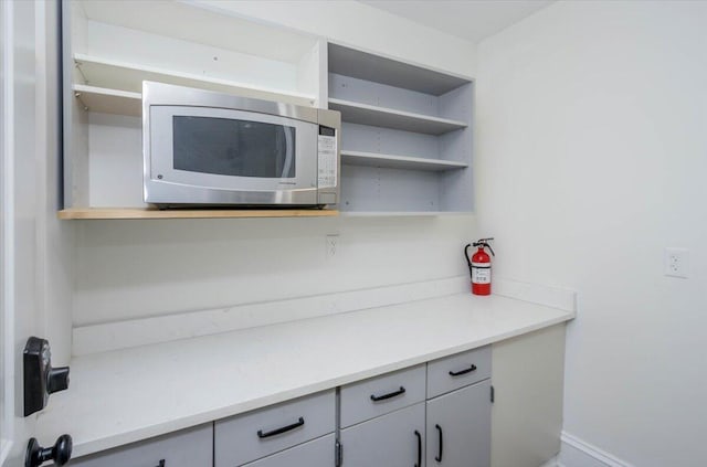 925 Beman St, Augusta, GA 30904 - kitchen featuring stainless steel microwave, open shelves, and gray cabinets