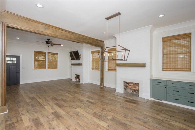 925 Beman St, Augusta, GA 30904 - unfurnished living room featuring a large fireplace, ornamental molding, baseboards, a ceiling fan, and dark wood-type flooring
