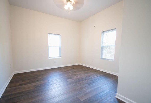 empty room with ceiling fan, dark hardwood / wood-style floors, and plenty of natural light