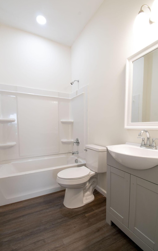 full bathroom with hardwood / wood-style flooring, toilet, vanity, and  shower combination