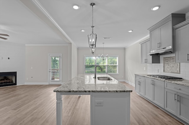 647 Bunchgrass St, Evans, GA 30809 - kitchen with a sink, gray cabinets, stainless steel gas cooktop, under cabinet range hood, and ornamental molding