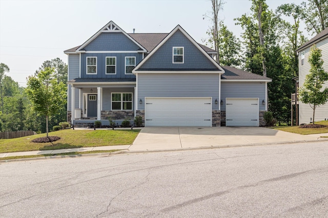 647 Bunchgrass St, Evans, GA 30809 - craftsman inspired home featuring stone siding, concrete driveway, a front lawn, a porch, and a garage