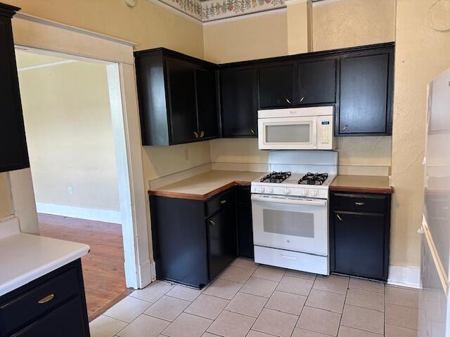 kitchen featuring light tile patterned floors and white appliances