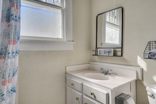 bathroom with vanity, toilet, and walk in shower