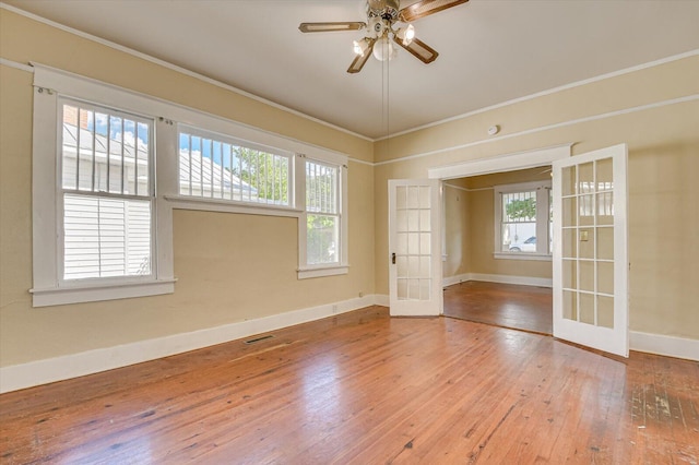 unfurnished room featuring a healthy amount of sunlight, french doors, and hardwood / wood-style floors