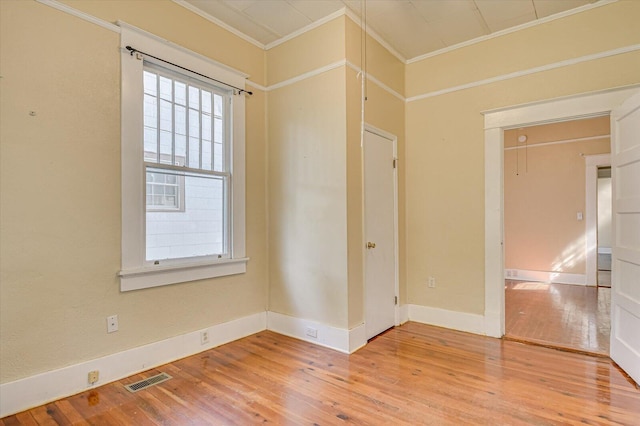 unfurnished room with hardwood / wood-style flooring and ornamental molding