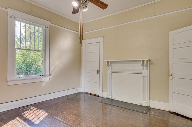 empty room with ceiling fan, dark wood-type flooring, and ornamental molding