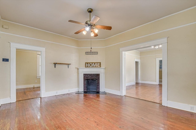 unfurnished living room with a fireplace, hardwood / wood-style floors, ceiling fan, and ornamental molding