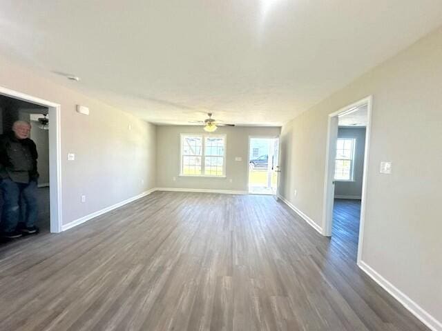 unfurnished living room with ceiling fan and dark hardwood / wood-style flooring