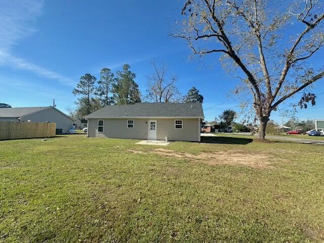 rear view of property featuring a lawn