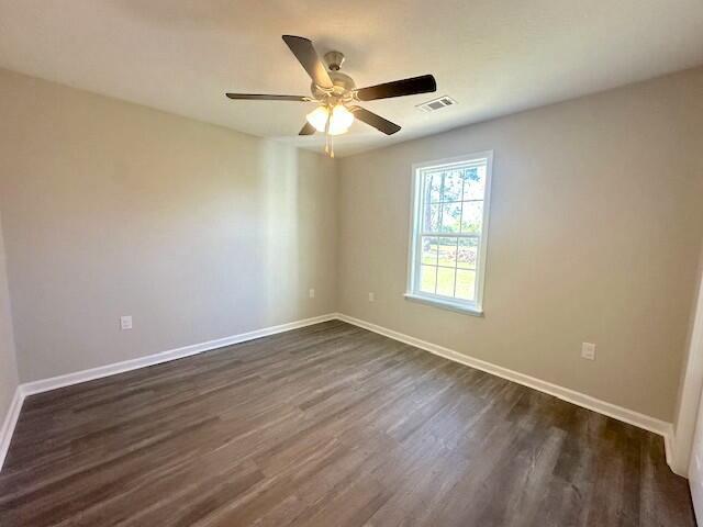 spare room featuring ceiling fan and dark hardwood / wood-style flooring