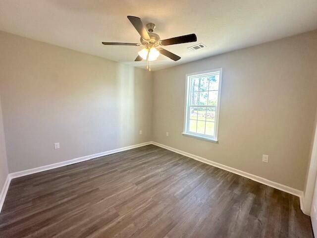spare room with dark hardwood / wood-style floors and ceiling fan