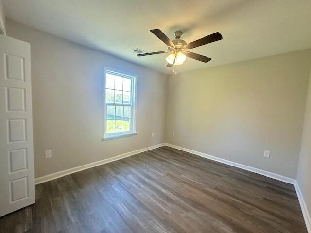 spare room featuring ceiling fan and dark hardwood / wood-style flooring