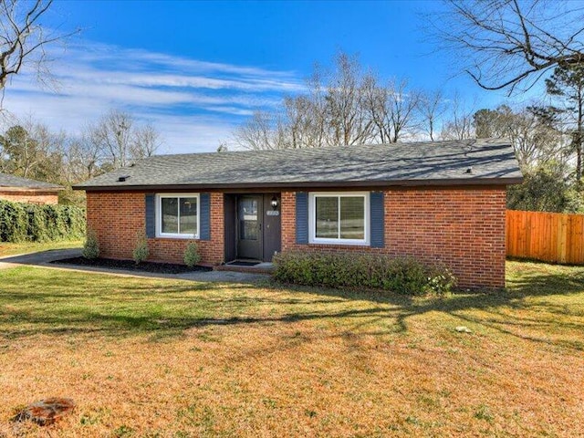 single story home with a front lawn, fence, and brick siding