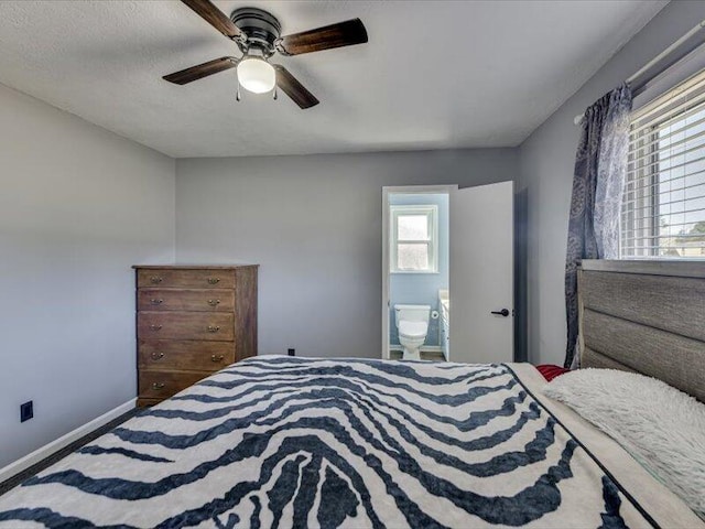 bedroom featuring connected bathroom, a ceiling fan, and baseboards