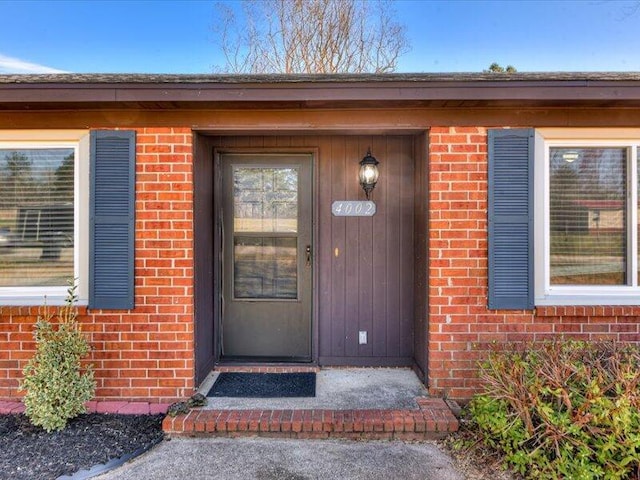 view of exterior entry featuring brick siding