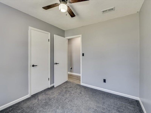 unfurnished bedroom with visible vents, baseboards, and carpet