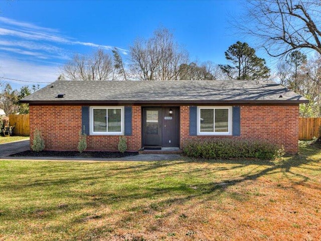 single story home featuring a front lawn, fence, and brick siding