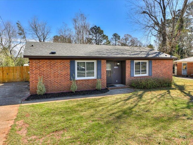 single story home with brick siding, a front lawn, and fence