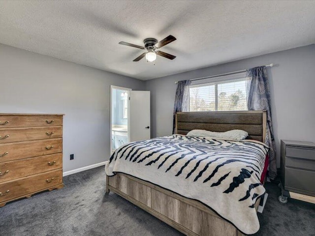 bedroom featuring baseboards, dark carpet, ensuite bathroom, a textured ceiling, and a ceiling fan