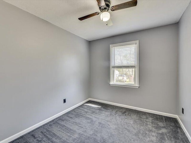 carpeted spare room with a ceiling fan and baseboards