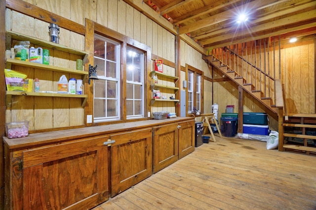 interior space with light hardwood / wood-style floors, wooden ceiling, and wooden walls