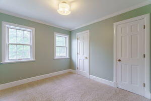 unfurnished bedroom featuring light colored carpet and ornamental molding