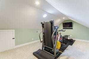 exercise room with carpet floors and lofted ceiling