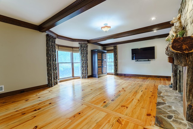 unfurnished living room with beam ceiling, ornamental molding, and light hardwood / wood-style flooring