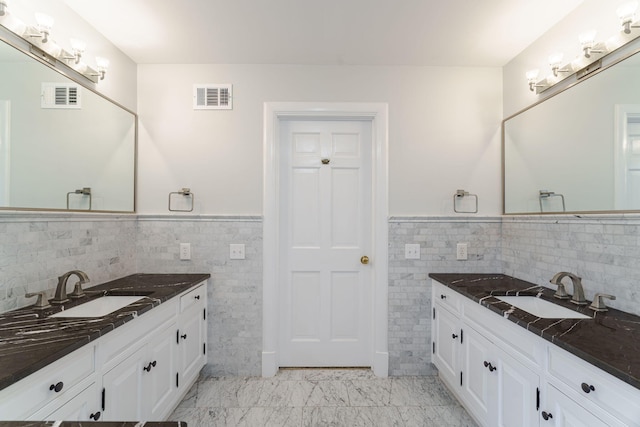 bathroom featuring vanity and tile walls