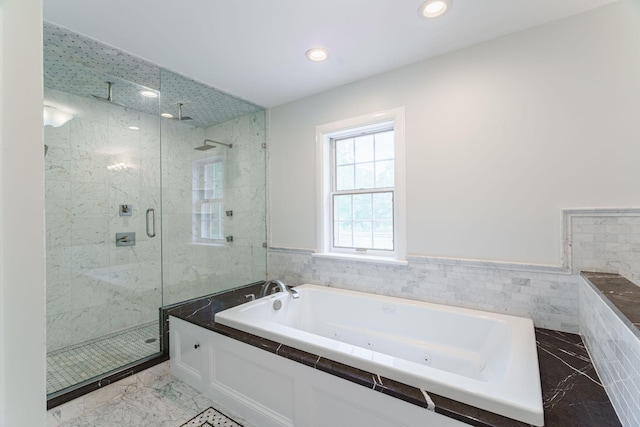 bathroom featuring shower with separate bathtub and tile walls