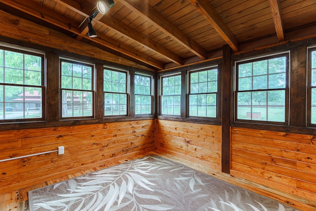 unfurnished sunroom featuring lofted ceiling with beams, wooden ceiling, and track lighting