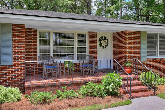 view of exterior entry featuring brick siding