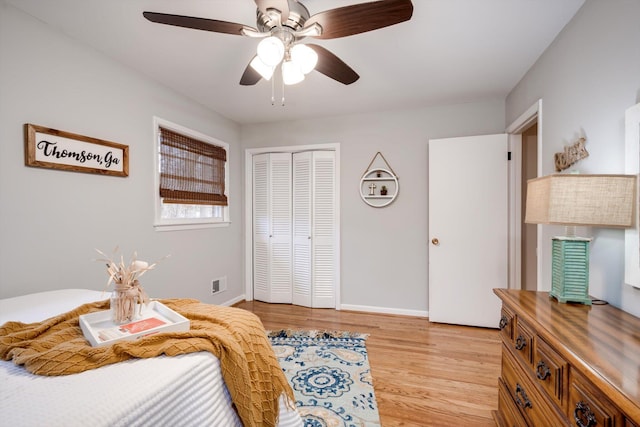 bedroom with light wood finished floors, a closet, baseboards, and a ceiling fan