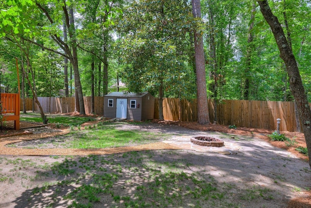 fenced backyard with an outdoor fire pit, a shed, and an outdoor structure