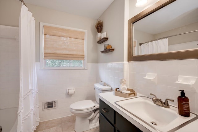 bathroom with tile walls, tile patterned floors, toilet, curtained shower, and vanity