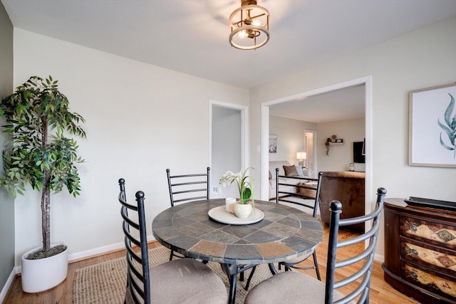 dining room featuring baseboards and light wood-style flooring