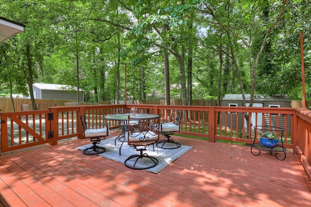 wooden deck with a storage shed, a fenced backyard, and an outdoor structure