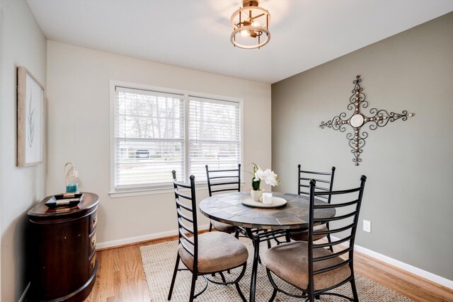 dining area with light wood finished floors and baseboards