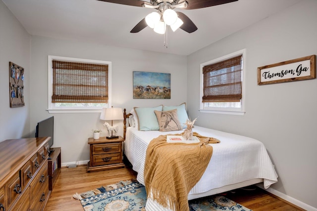 bedroom with light wood-style floors, baseboards, and a ceiling fan