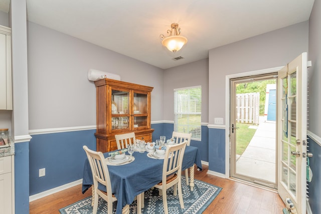 dining room featuring visible vents, light wood finished floors, and baseboards