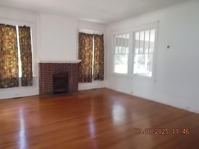 1420 Heath St, Augusta, GA 30904 - unfurnished living room featuring wood finished floors and a brick fireplace