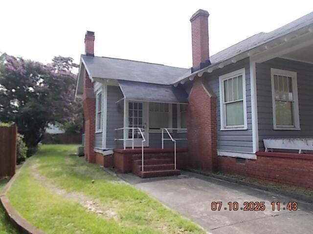 1420 Heath St, Augusta, GA 30904 - view of side of home with covered porch, a chimney, and a yard