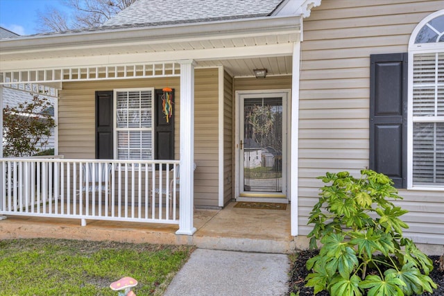 property entrance with a shingled roof and a porch