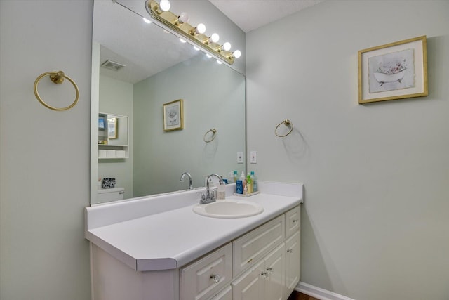 bathroom with baseboards, visible vents, and vanity