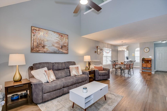 living room featuring a ceiling fan, baseboards, and wood finished floors