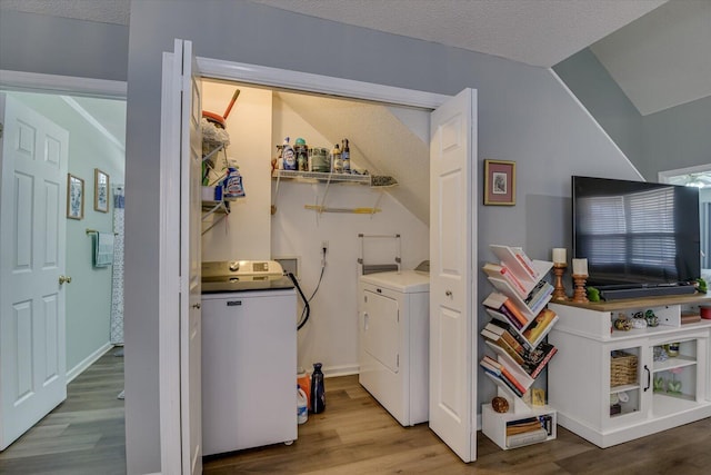 laundry room featuring a textured ceiling, separate washer and dryer, and wood finished floors