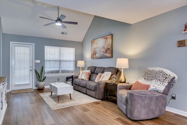 living room with lofted ceiling, ceiling fan, wood finished floors, visible vents, and baseboards