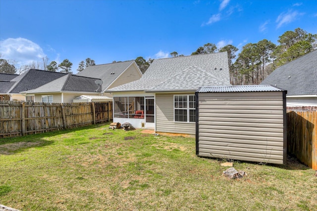 back of house featuring a sunroom, a fenced backyard, a shingled roof, and a yard