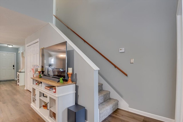 stairway featuring baseboards and wood finished floors